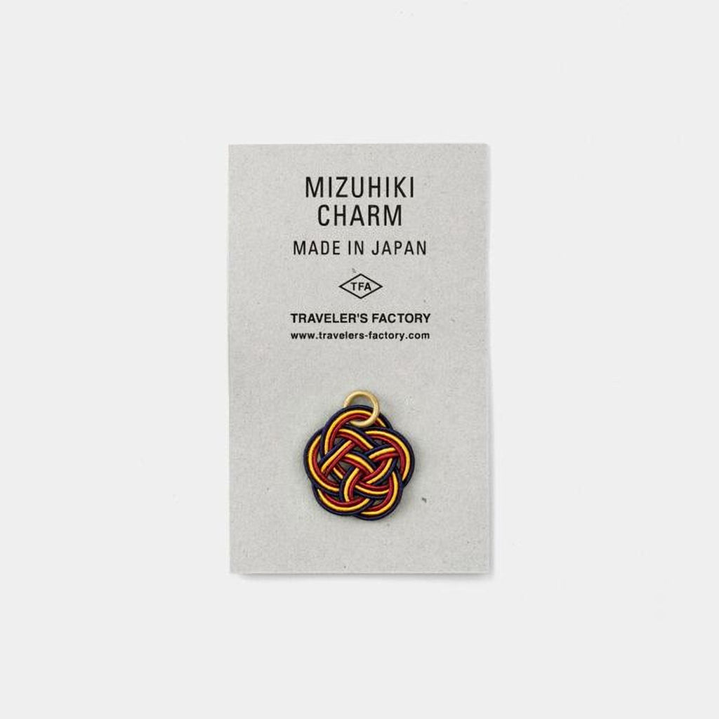The image is a product advertisement for a charm, specifically the Mizuhiki charm, which is made in Japan. The charm is displayed on a gray background, and there is a website address provided for further information.