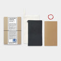 a collection of travel-related items, including a brown paper bag, a black notebook, a white cloth, and a red string.