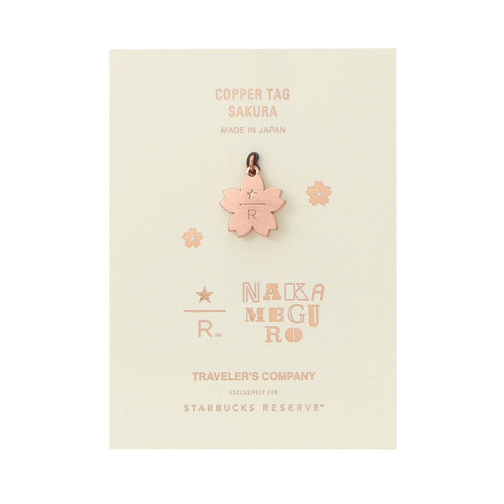 The image is a promotional material for a copper tag featuring a cherry blossom design, with text and logos related to the brand.