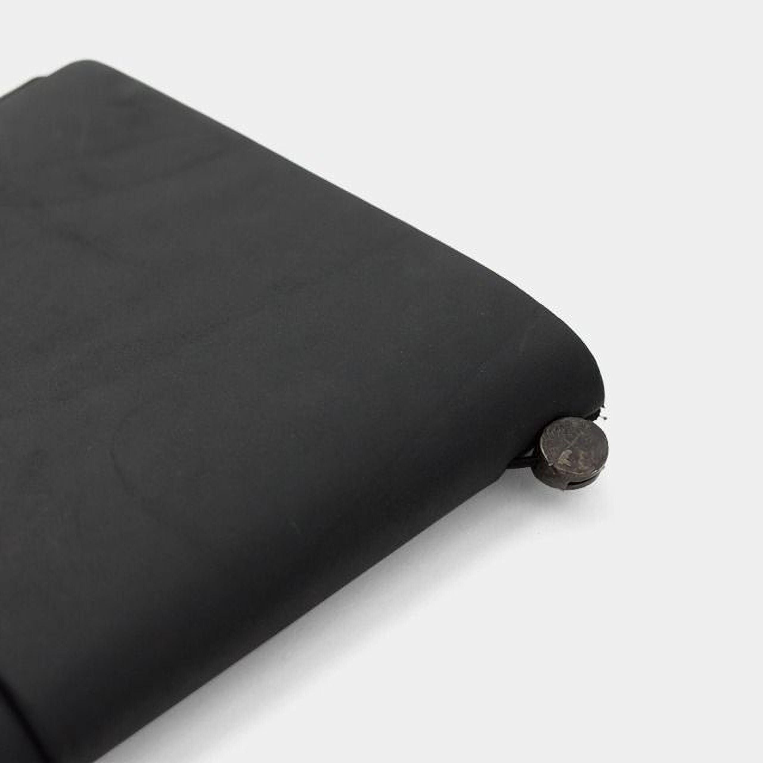 A black, rectangular object with a circular object attached to it, sitting on a white surface.
