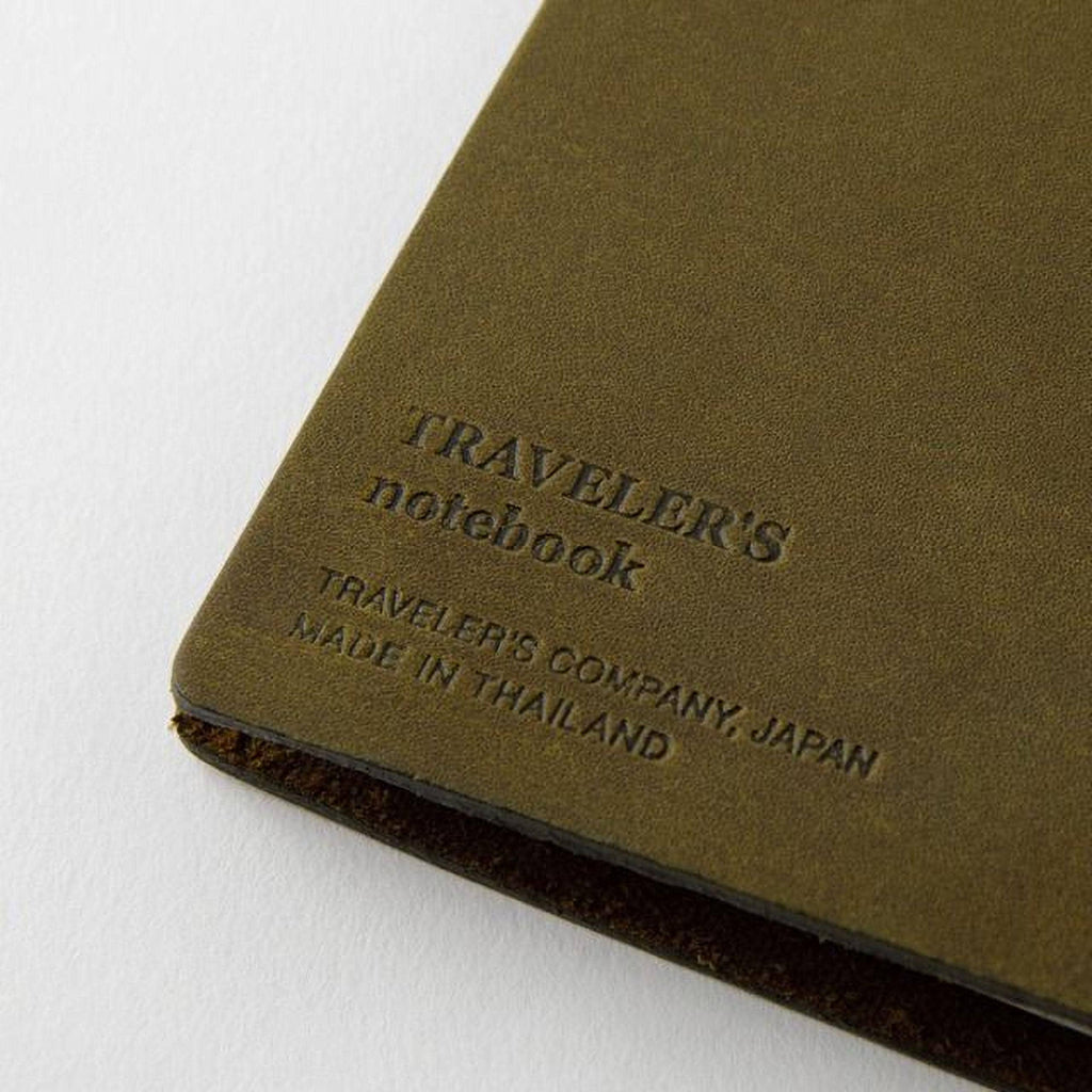 A close-up image of a brown leather-like notebook with embossed text on the cover.
