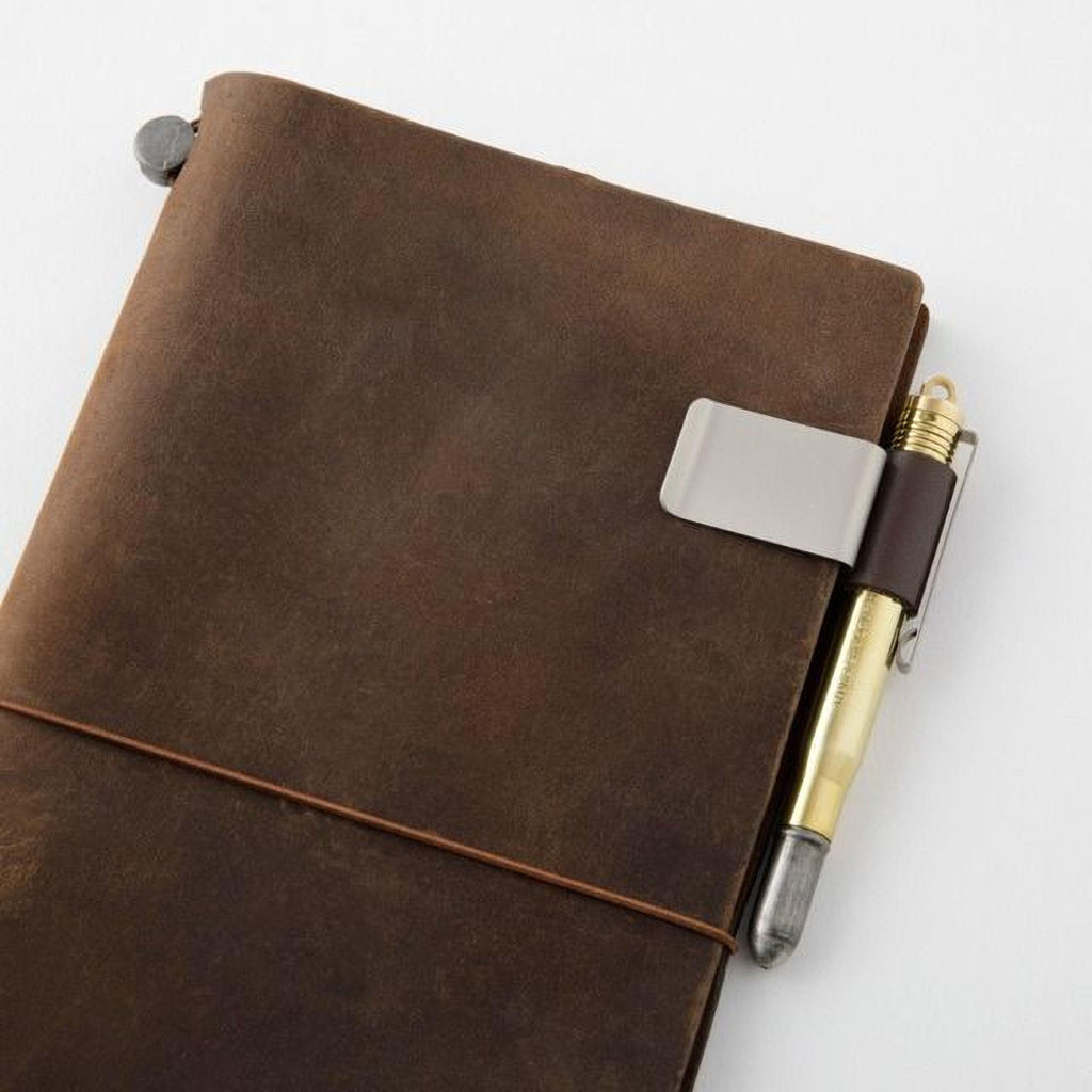 A brown leather-bound notebook with a pen clip attached to the top right corner.