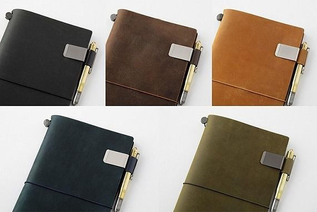 a collection of five leather-bound notebooks in various colors, including black, brown, green, and orange. Each notebook has a pen clip attached to the cover, suggesting they are designed for use with pens.