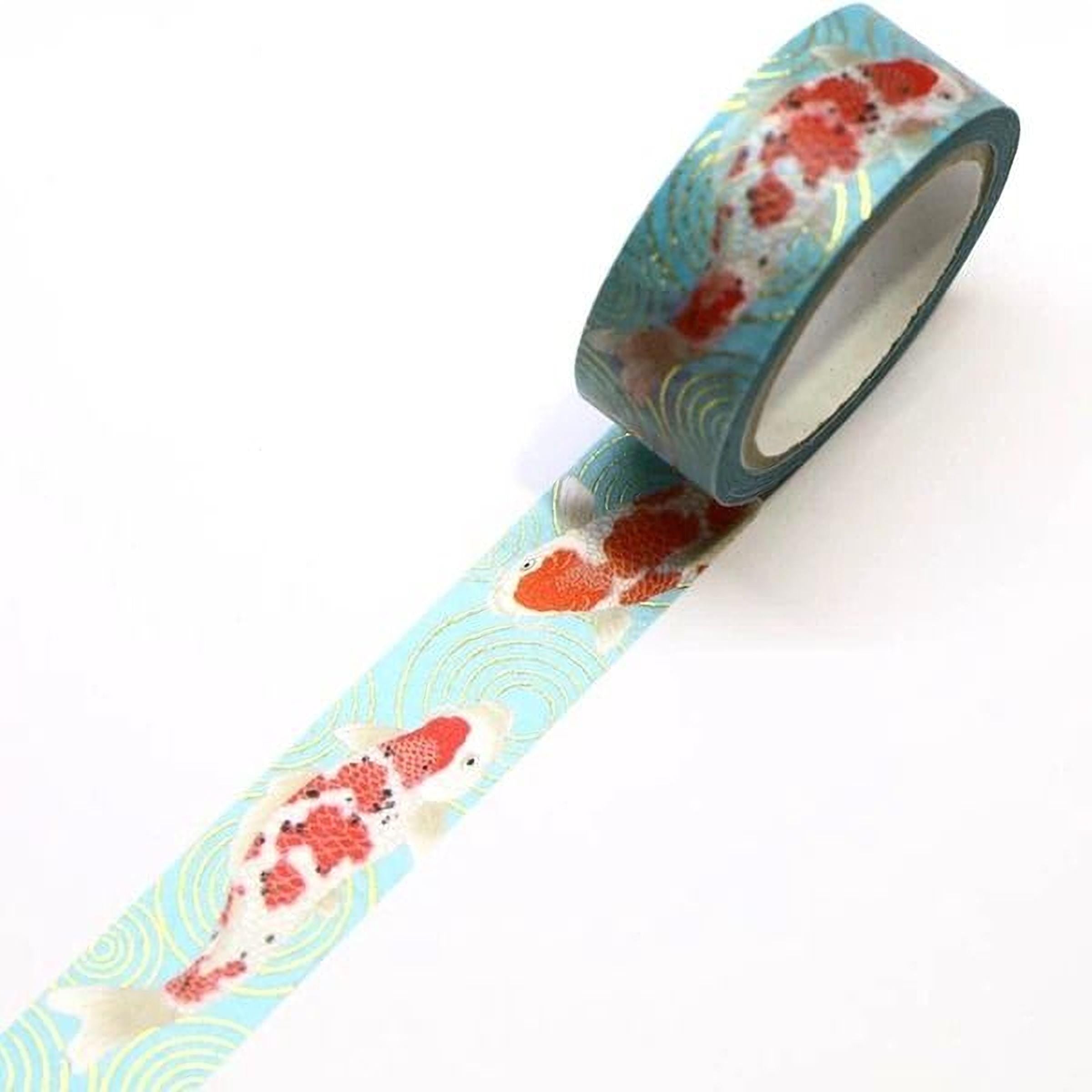 A roll of blue and green patterned tape with a fish design on it, lying on a white surface.