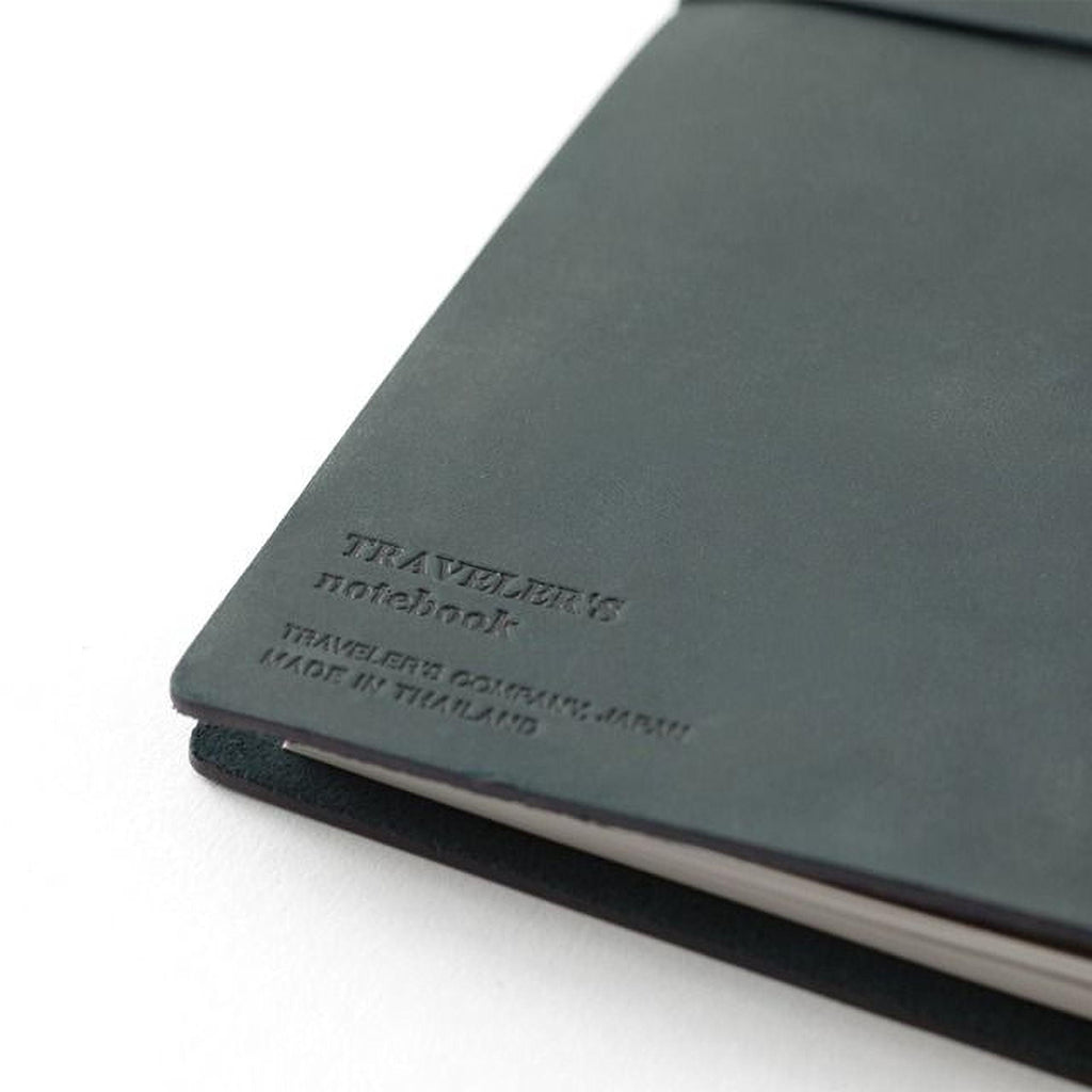 a close-up view of a black leather-bound notebook with embossed text on the cover.