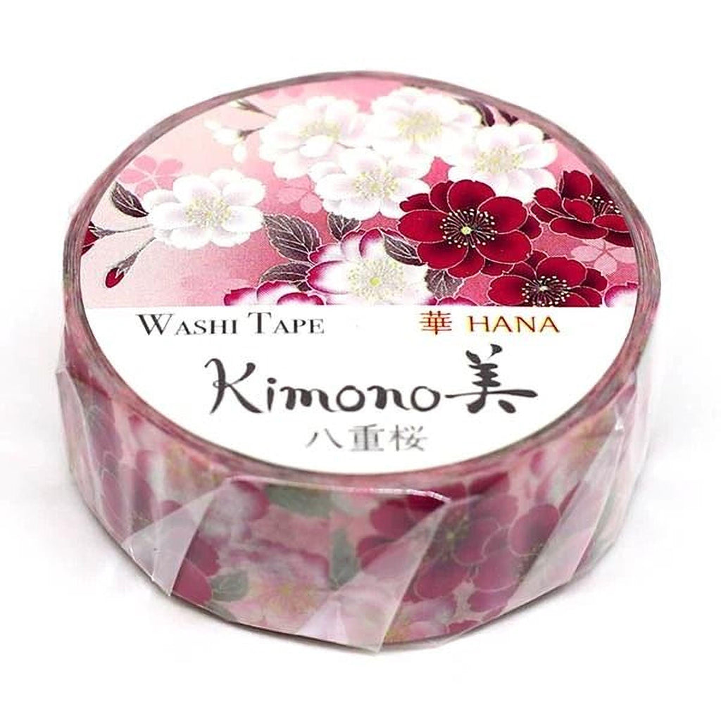 A round, pink and white floral patterned roll of washi tape with the brand name "Kimono" printed on it.