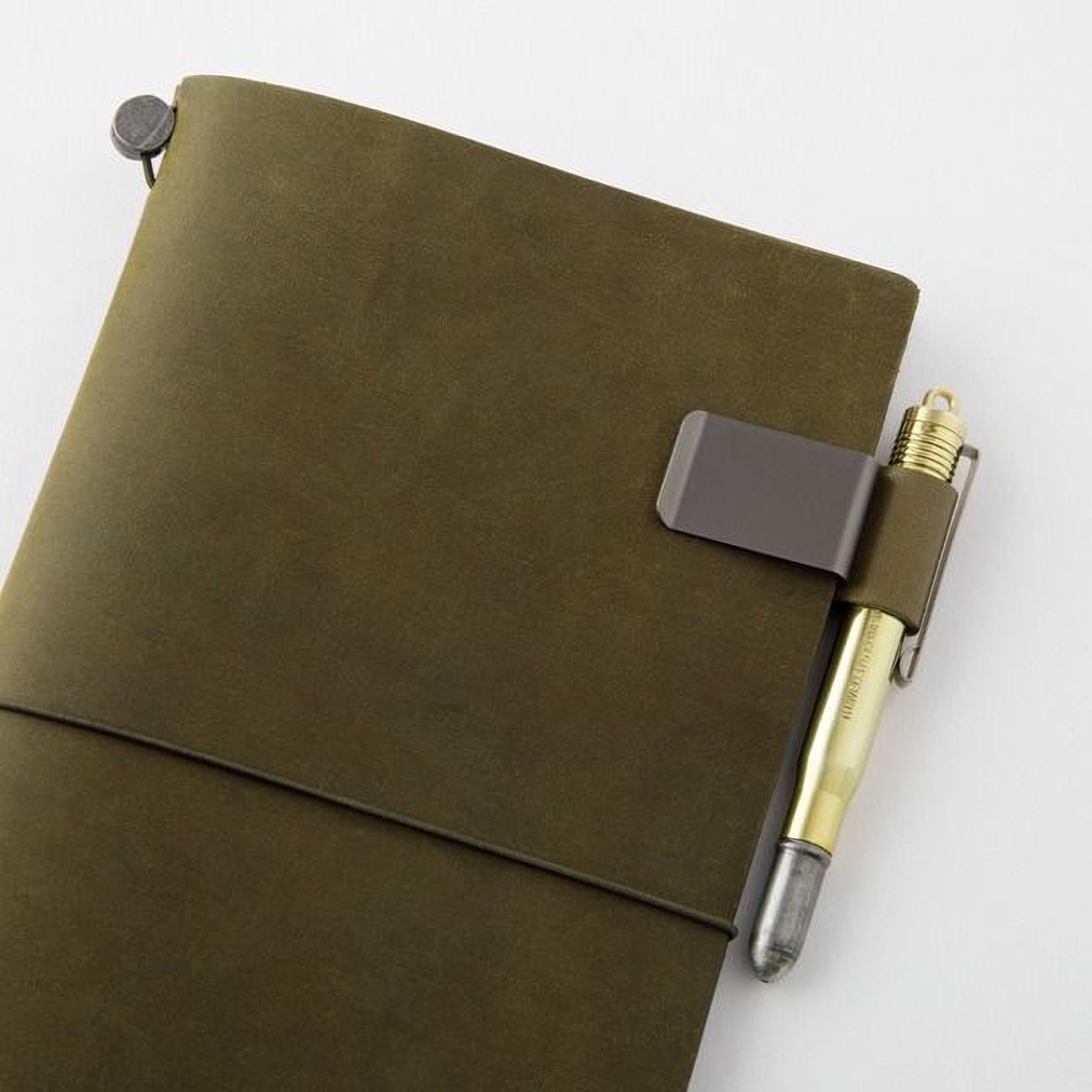 A dark green leather-like notebook with a pen clip attached to it.