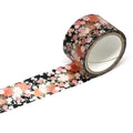 A roll of floral patterned tape is lying on a white surface, with the tape partially unwinding and revealing a floral pattern.