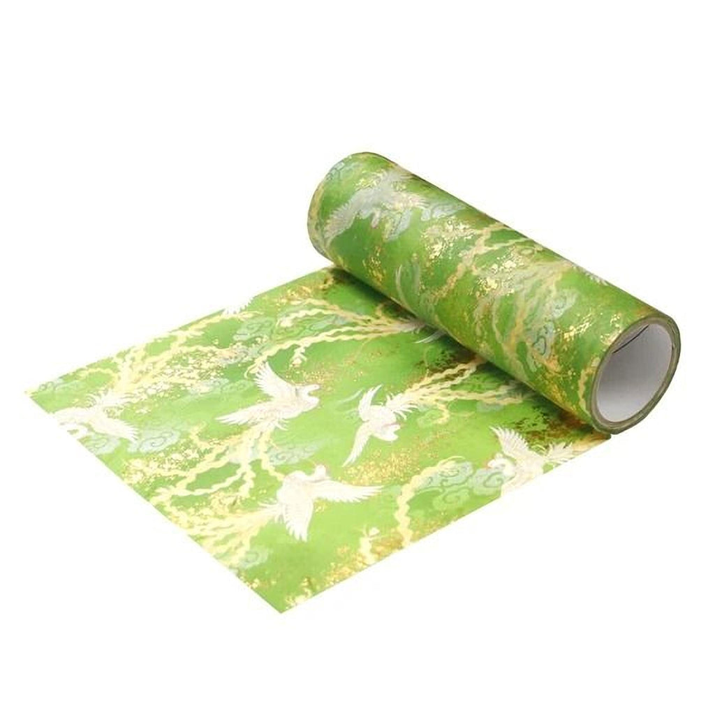 A roll of green and gold wrapping paper with a pattern of white birds on it, lying on a white surface.