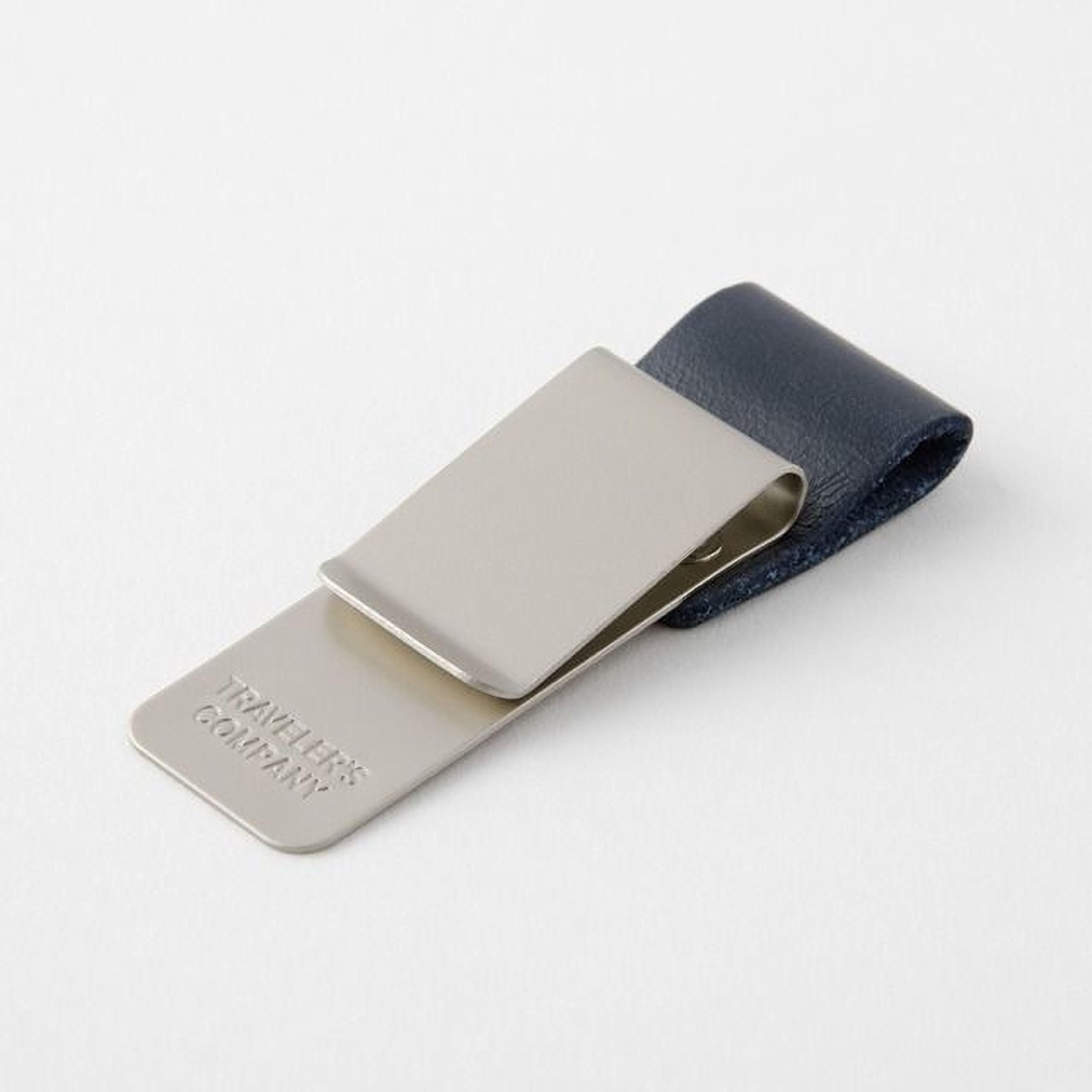 A silver metal money clip with a black leather loop attached to it.