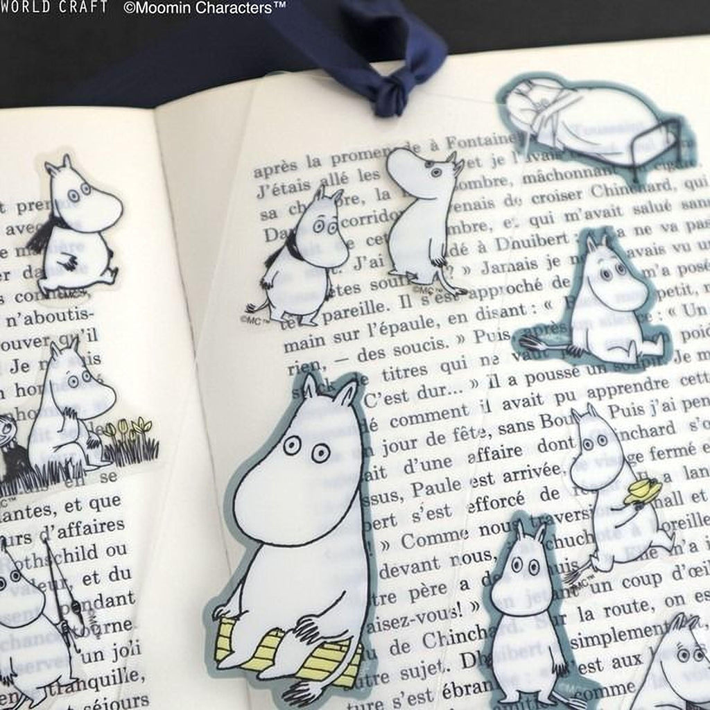 a collection of cartoon character stickers on a page of text, with various Moomin characters depicted in different poses and expressions.