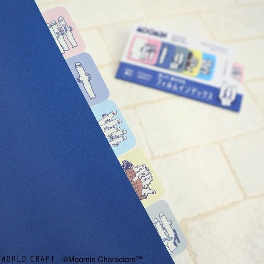 a blue folder with colorful page dividers, and there is a blurry background with a card or document.