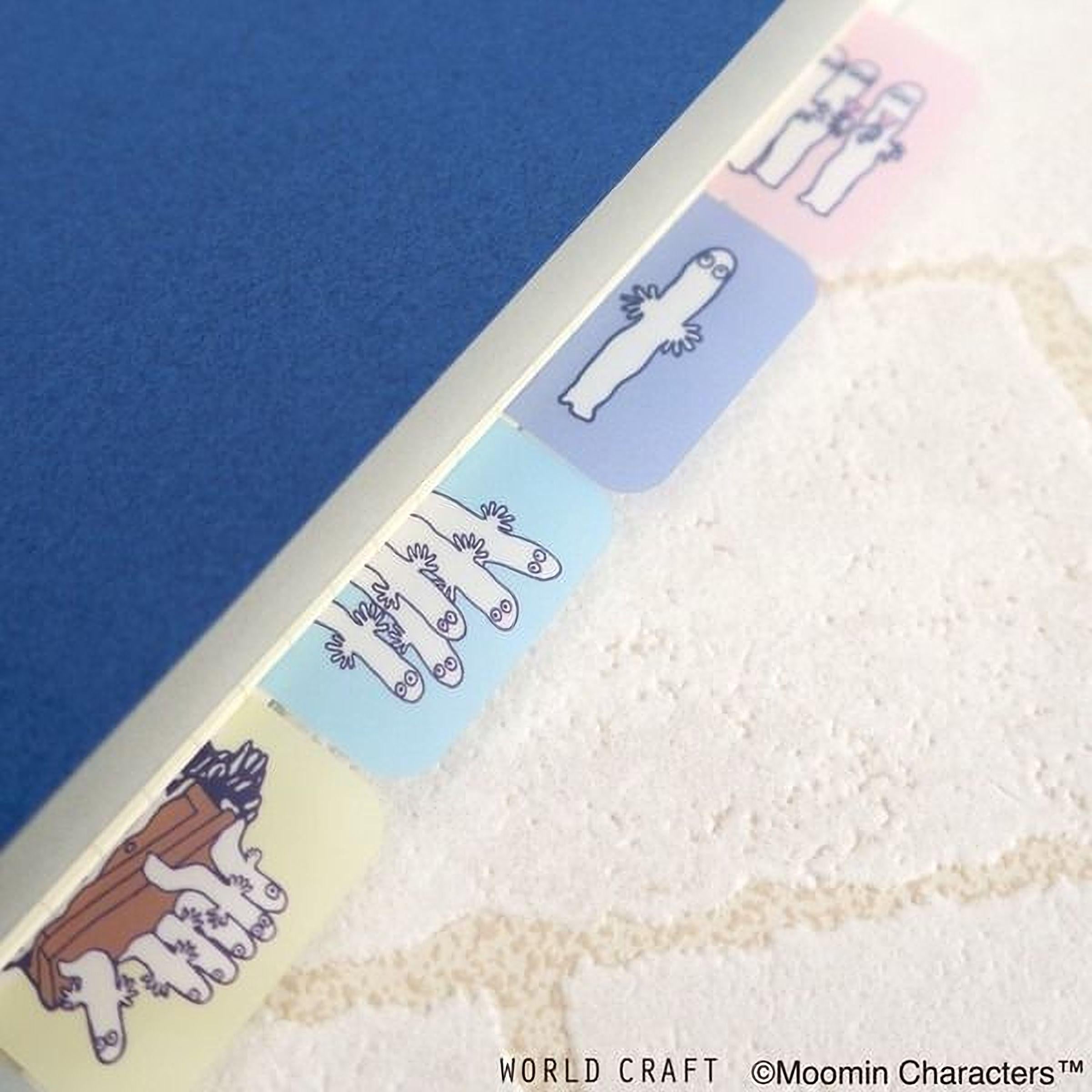 A close-up view of a blue surface with colorful, cartoon-like character stickers or labels attached to it.