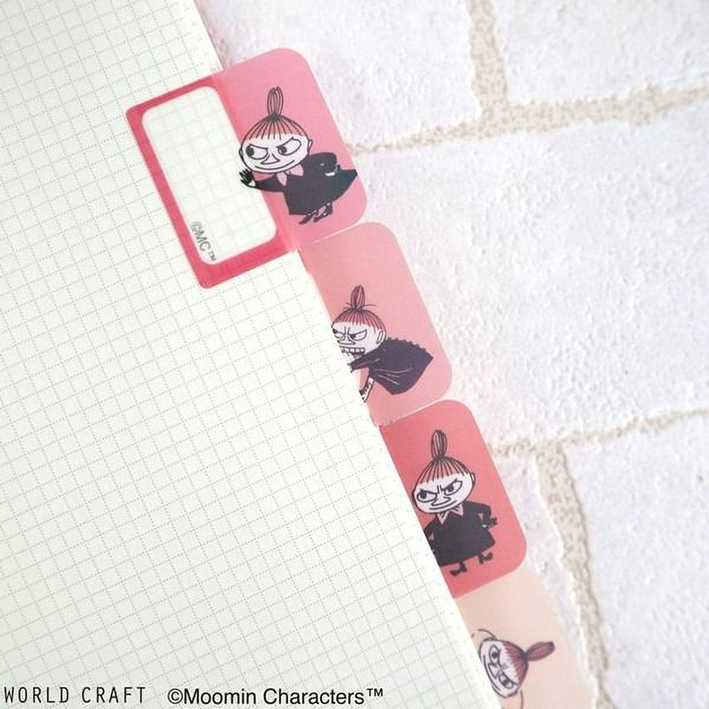 a close-up view of a white notebook with pink dividers, each divider containing a cartoon character. The dividers are arranged in a row, with the first one having a pink frame and the second one having a pink frame with a black character. The image does not contain any text, and the dividers are not described as being part of a larger collage or a series of images.