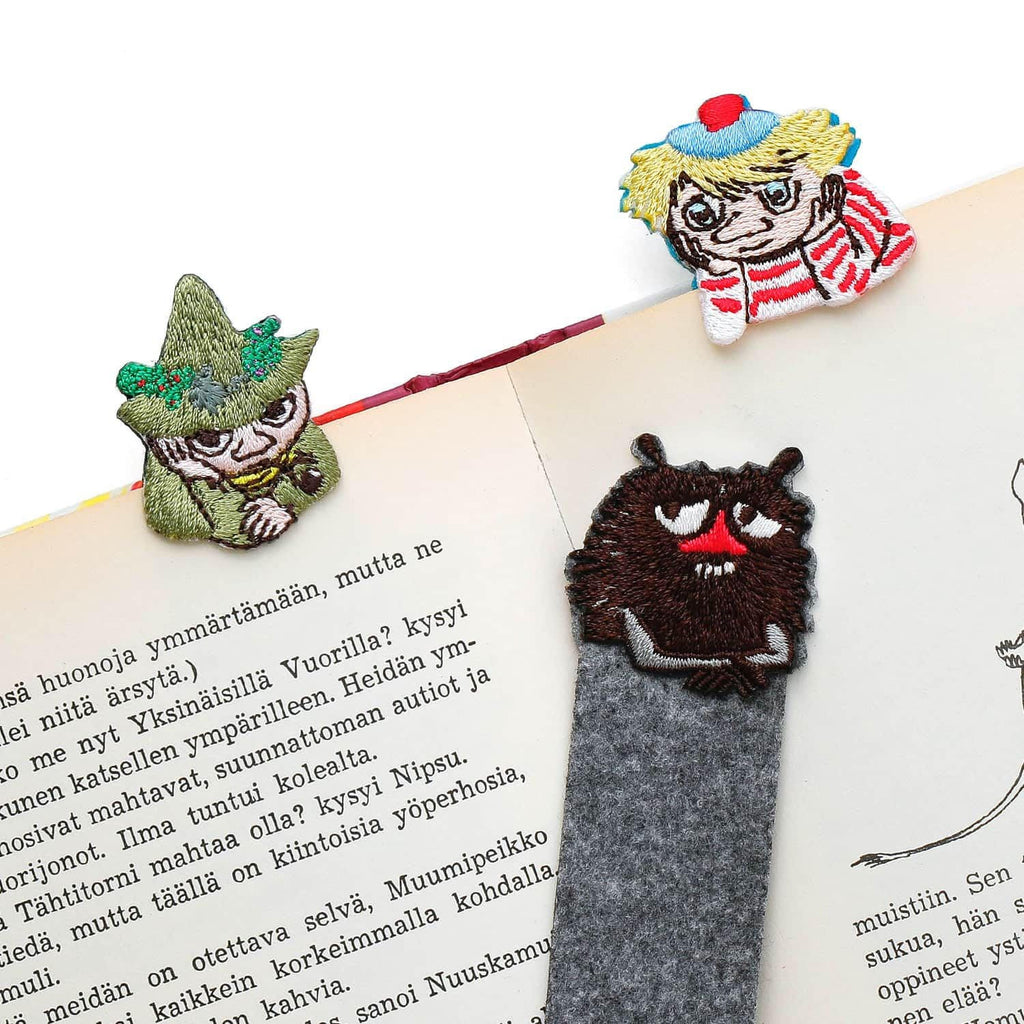 a gray bookmark with a cartoon character on it, placed on top of a page of text.