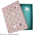 a pink box with a floral pattern and a teal lid, both adorned with illustrations of Moomin characters.