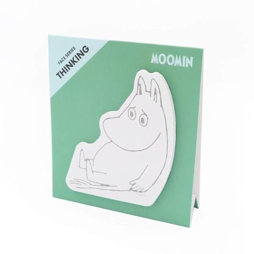 A green card with a white sticker of a cartoon character, which appears to be a character from the Moomin series.