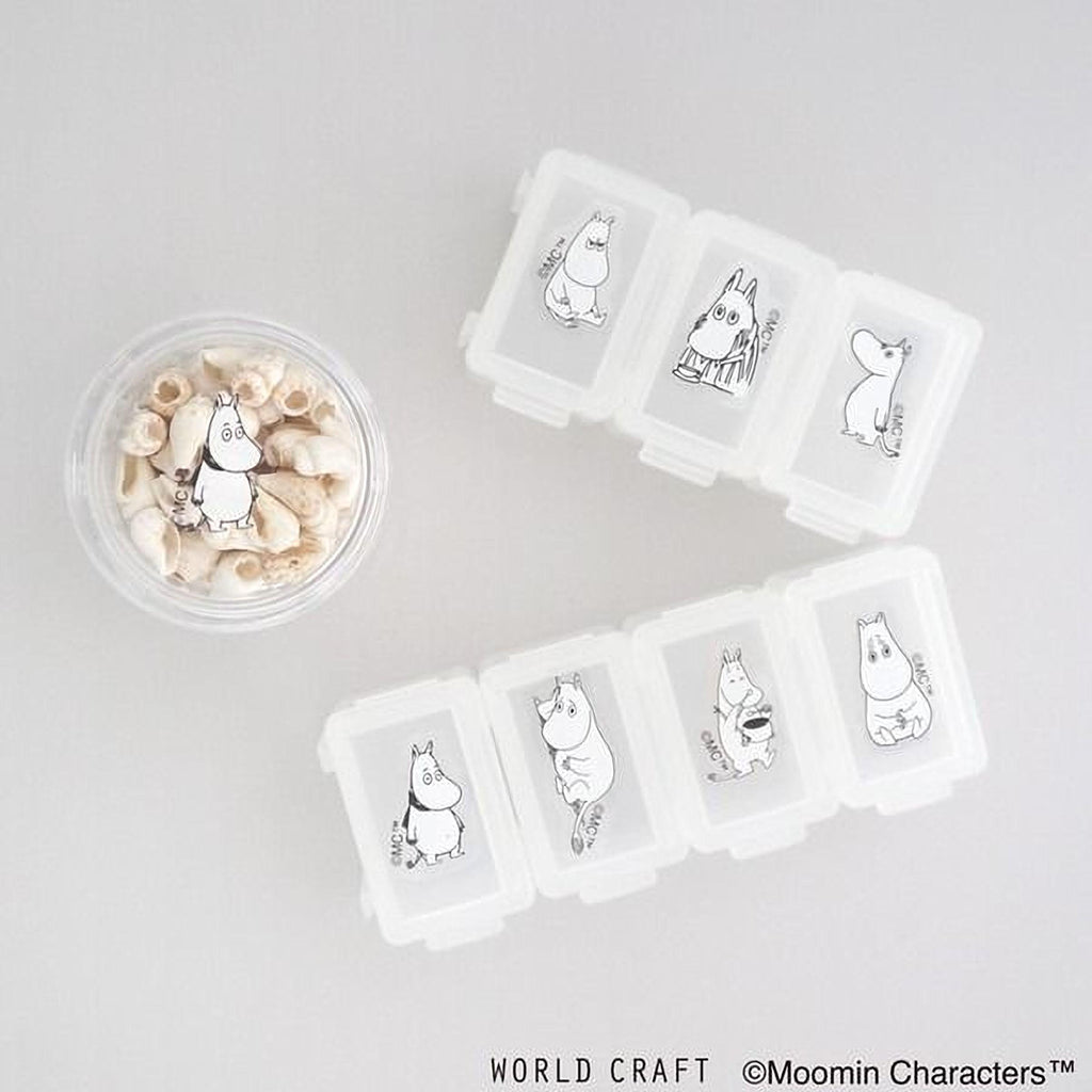a collection of small containers with illustrations of Moomin characters, along with a small bowl containing seashells.