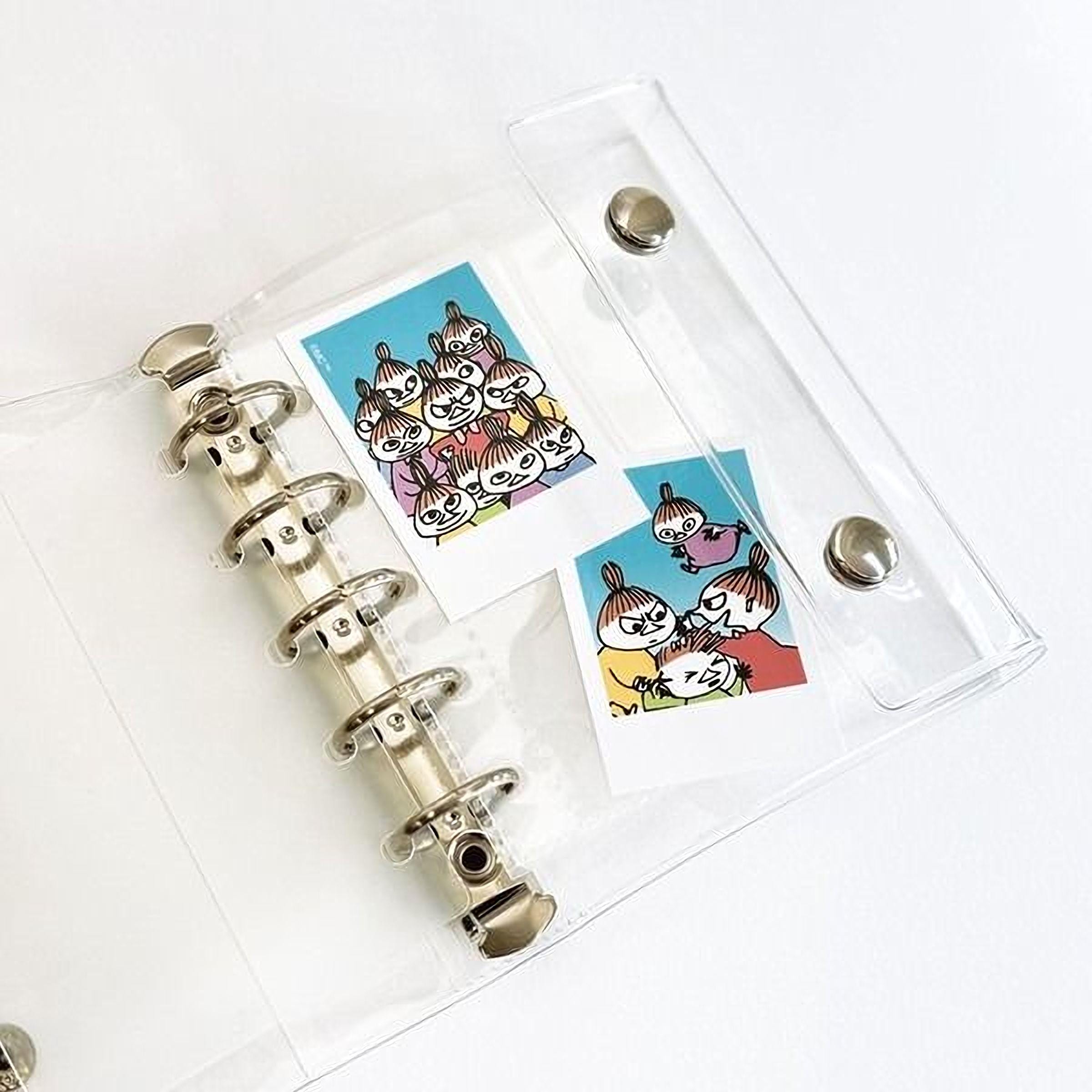 a clear plastic binder with two pages, each containing a colorful illustration of cartoon characters.
