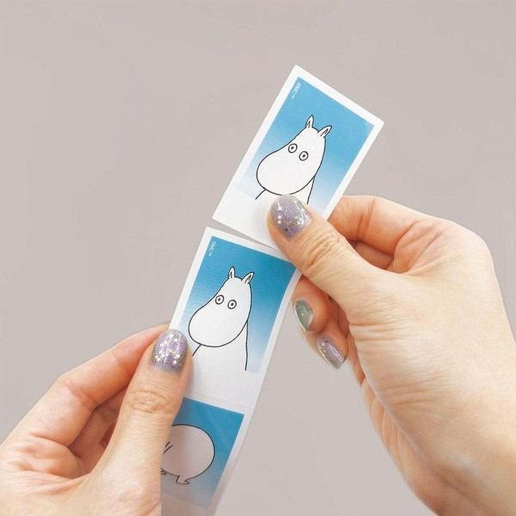A pair of hands holding two identical cards with a cartoon character on them.