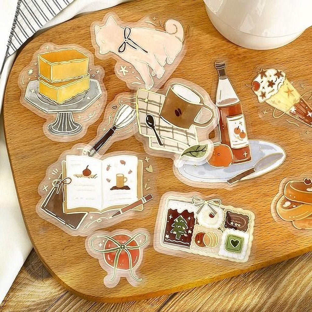 various food-related items, including a cake, a cup, a book, a bowl, and other food-related objects, all arranged on a wooden surface.