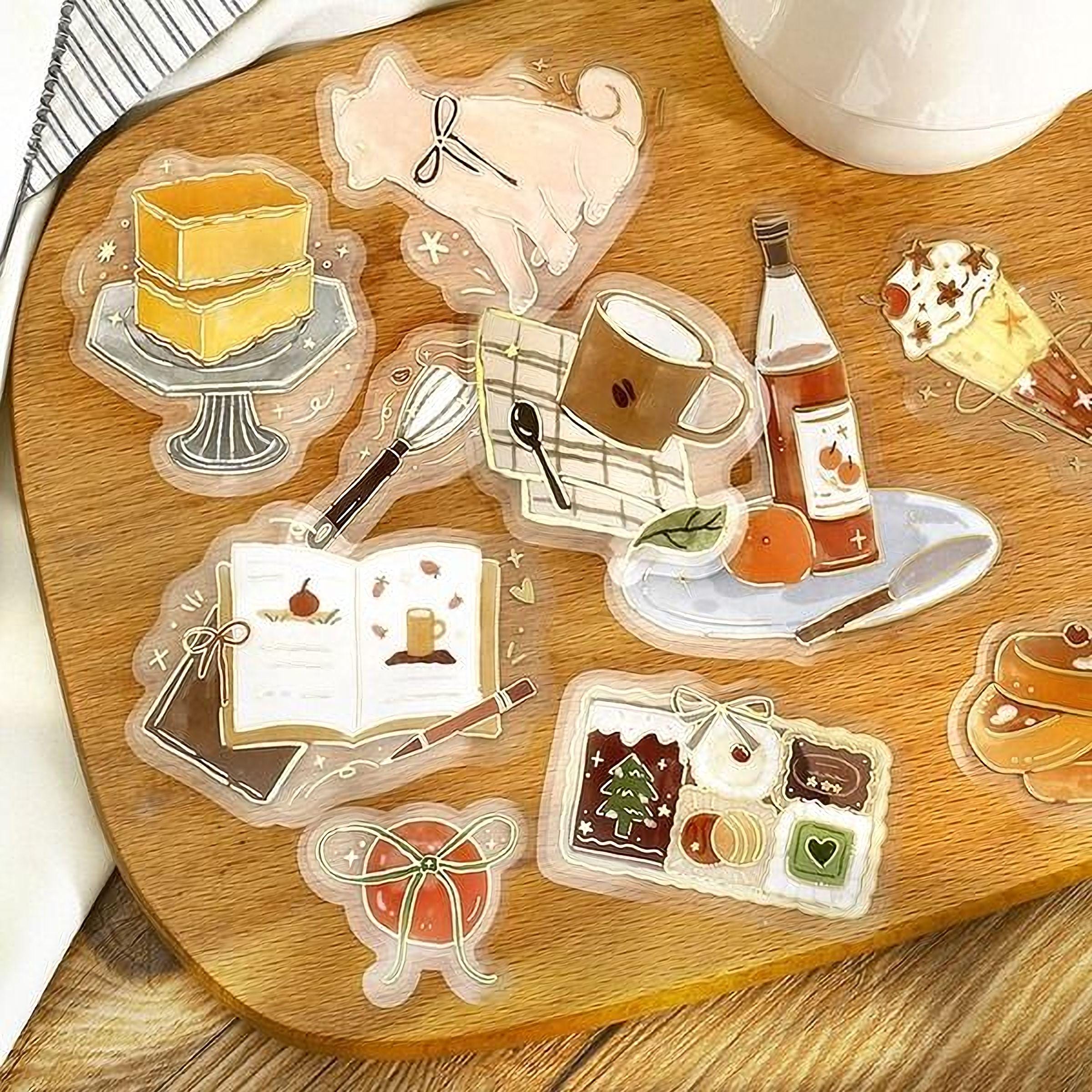 various food-related items, including a cake, a cup, a book, a bowl, and other food-related objects, all arranged on a wooden surface.
