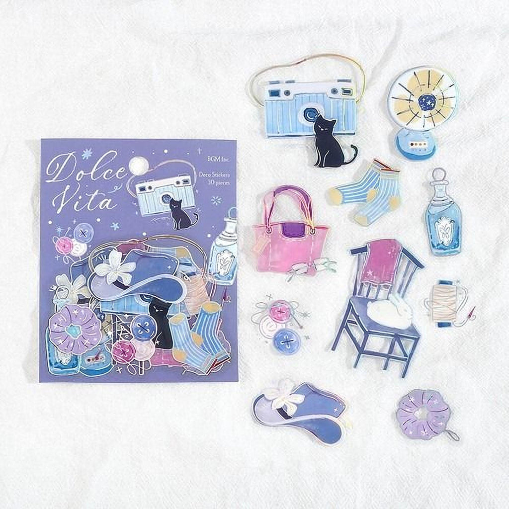 various cut-out shapes and illustrations of a doll, a camera, and other decorative items, all set against a purple background.