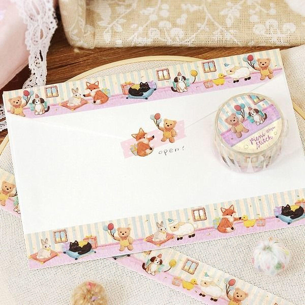 a decorative envelope and a roll of decorative tape with a cartoon animal theme.
