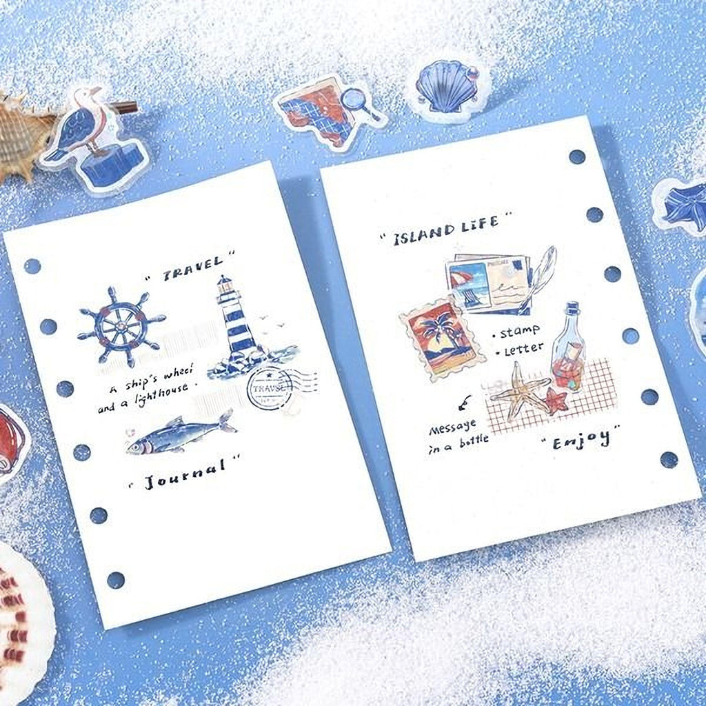 two notebooks with illustrations and text related to travel and island life, including a ship's wheel, lighthouse, stamps, a bottle, a message in a bottle, and a lighthouse.