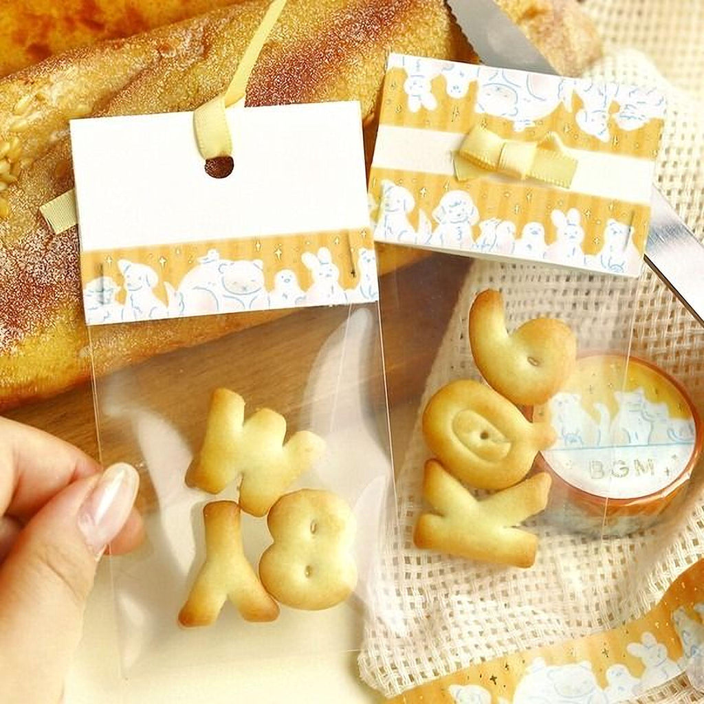 a variety of cookies and a card with animal designs, including a yellow ribbon and a yellow bow.