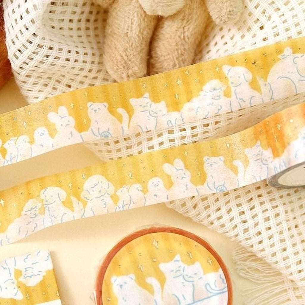 a yellow and white striped tape with a playful cat and dog design, along with a small round container with a similar cat and dog design.