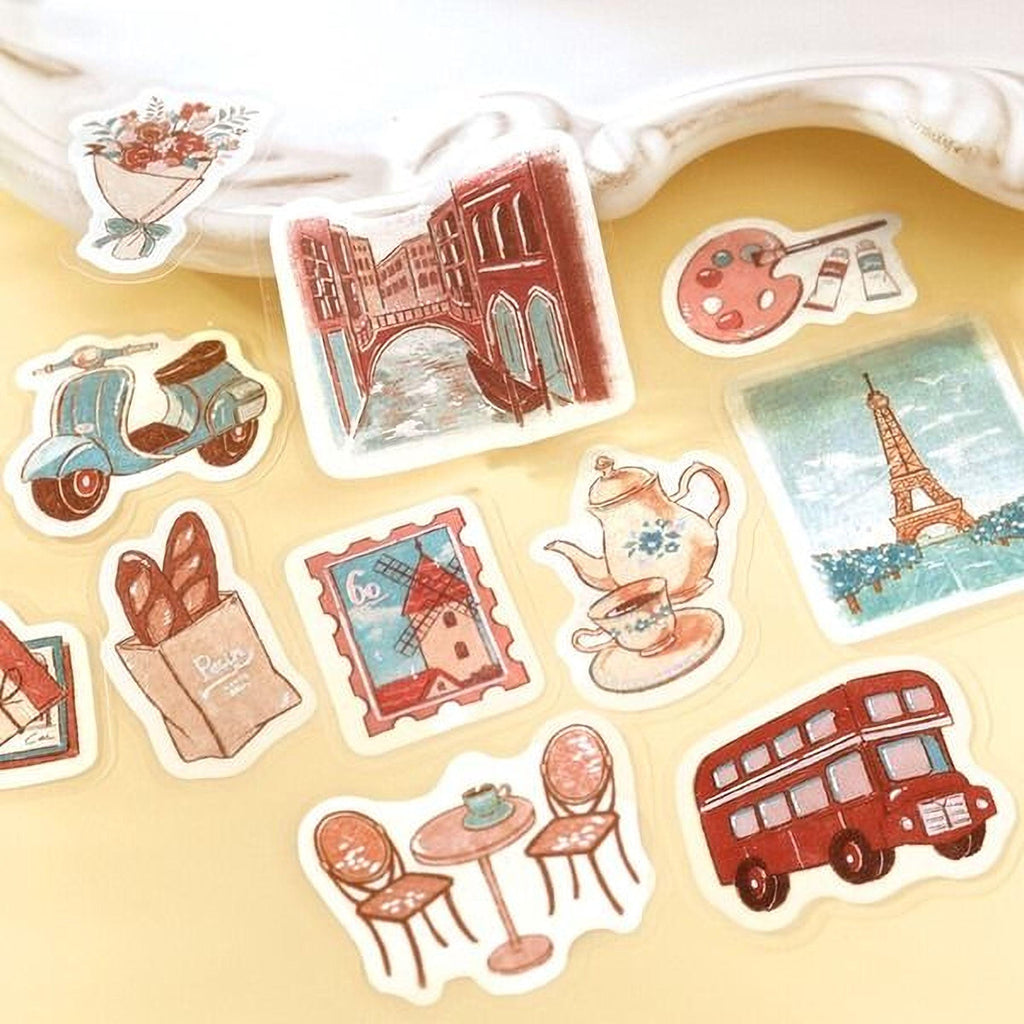 a collection of various stickers depicting different objects and scenes, including a moped, a bridge, a teapot, a double-decker bus, and a table with chairs.