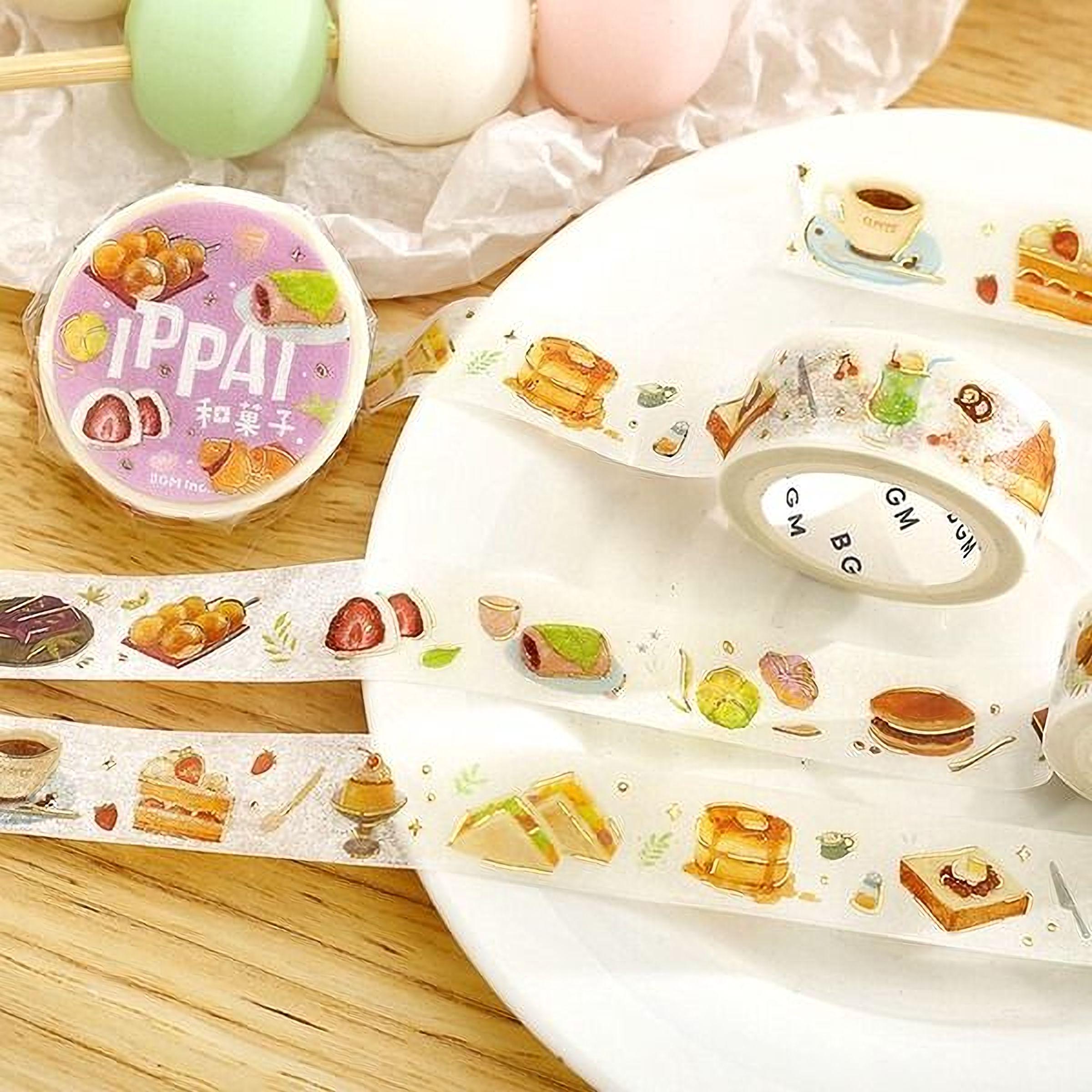 a variety of food-themed items, including a plate with pastries, a roll of food-themed tape, and a small container of food.