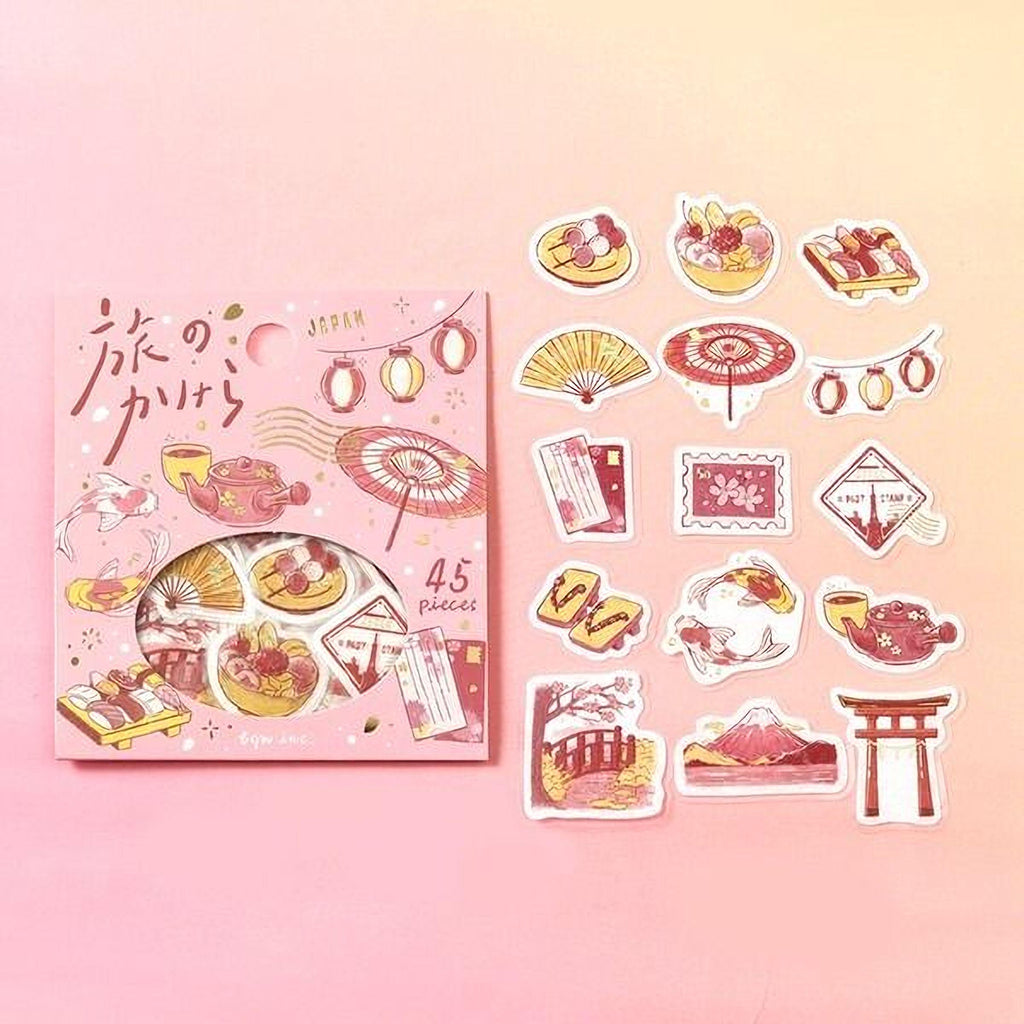a pink box containing various Japanese-themed stickers, including a fan, a teapot, a pagoda, and other cultural symbols. The box is labeled with the number "45 pieces" and the word "JAPAN" written on it.