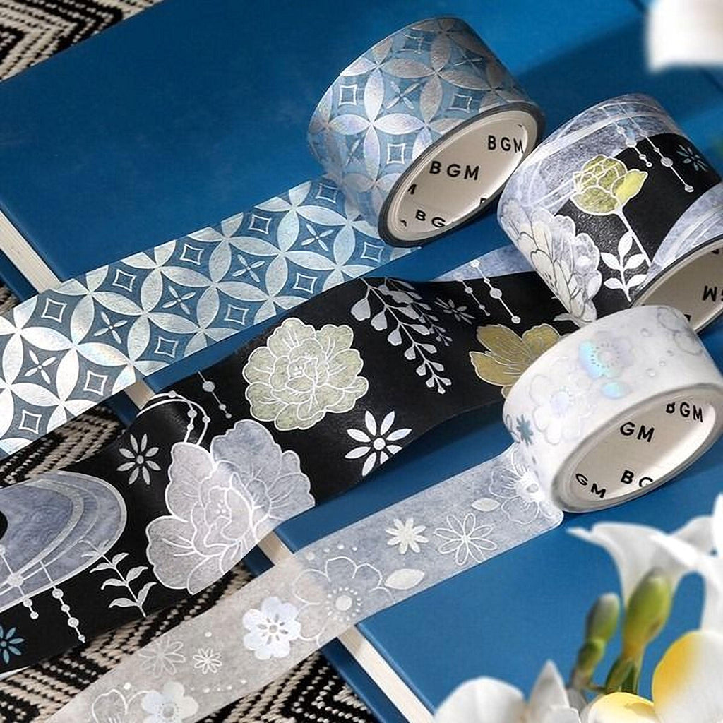 a collection of patterned and metallic tape rolls arranged on a blue surface, with some of the rolls partially overlapping each other.