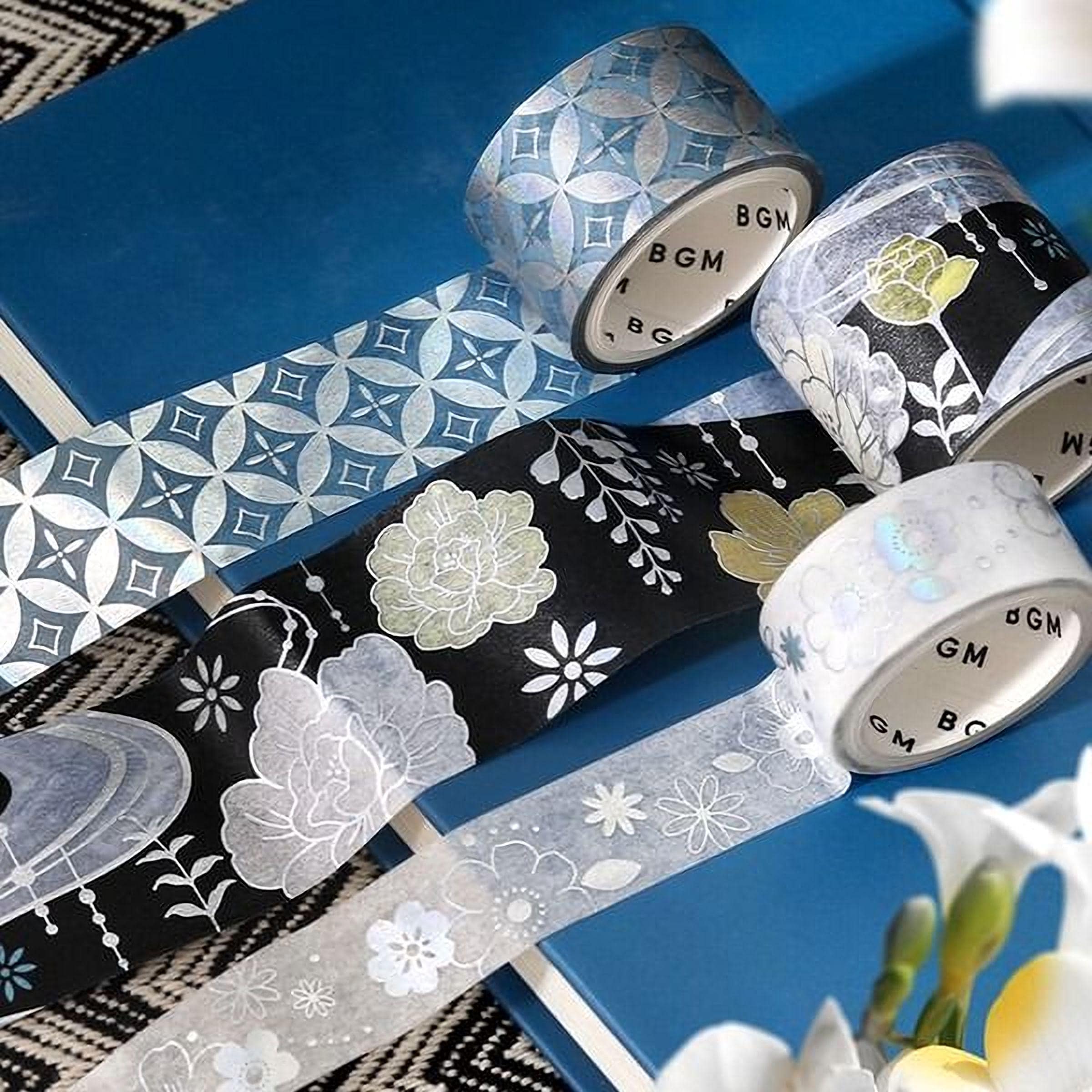 a collection of patterned and metallic tape rolls arranged on a blue surface, with some of the rolls partially overlapping each other.