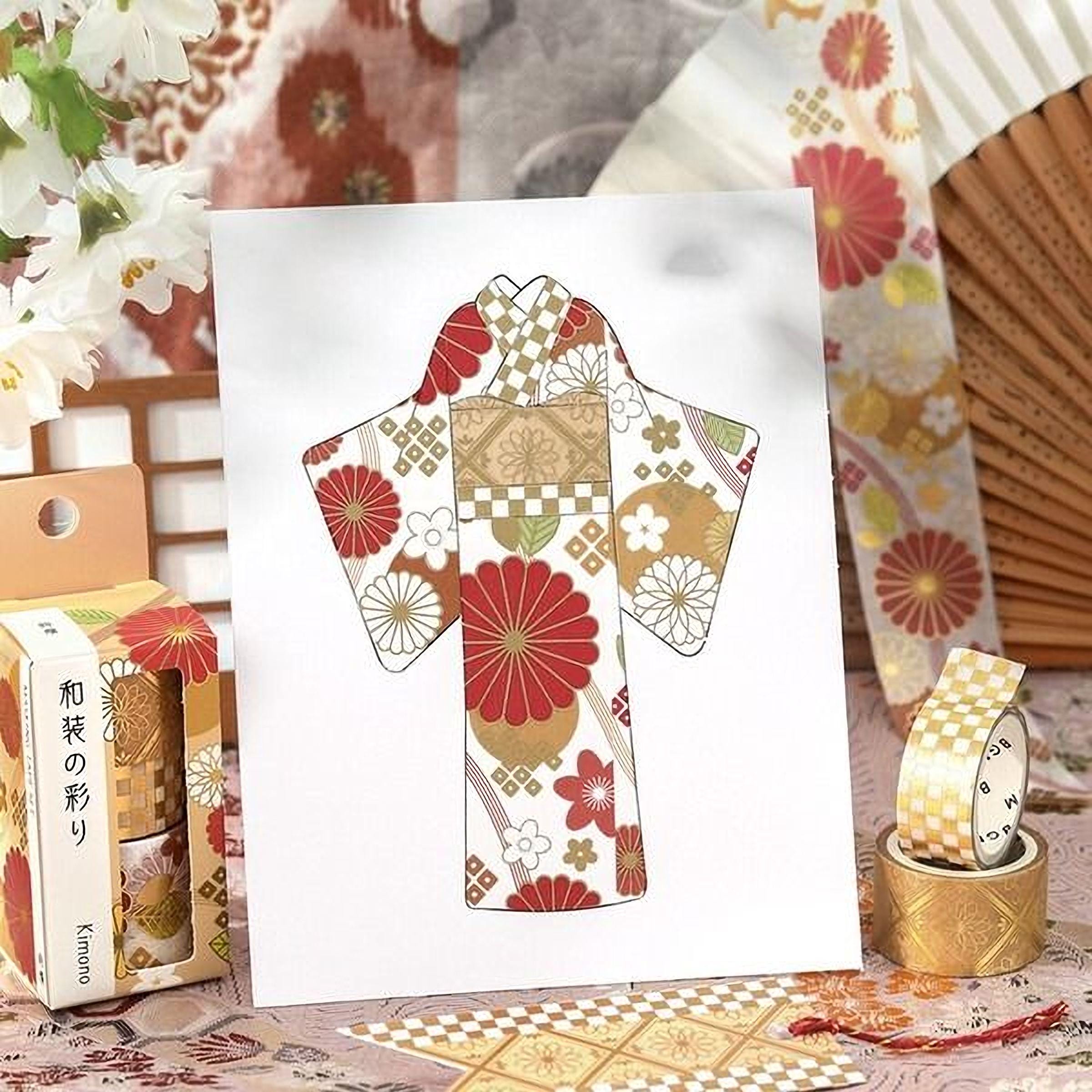 a white card with a floral pattern, surrounded by various decorative items such as a fan, a box of tissue paper, and a roll of tape.