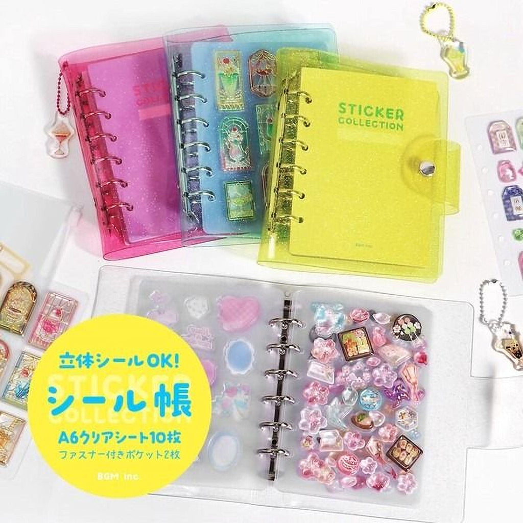 A collection of colorful notebooks and stickers, including a yellow sticker book and a pink notebook, along with various stickers and charms.