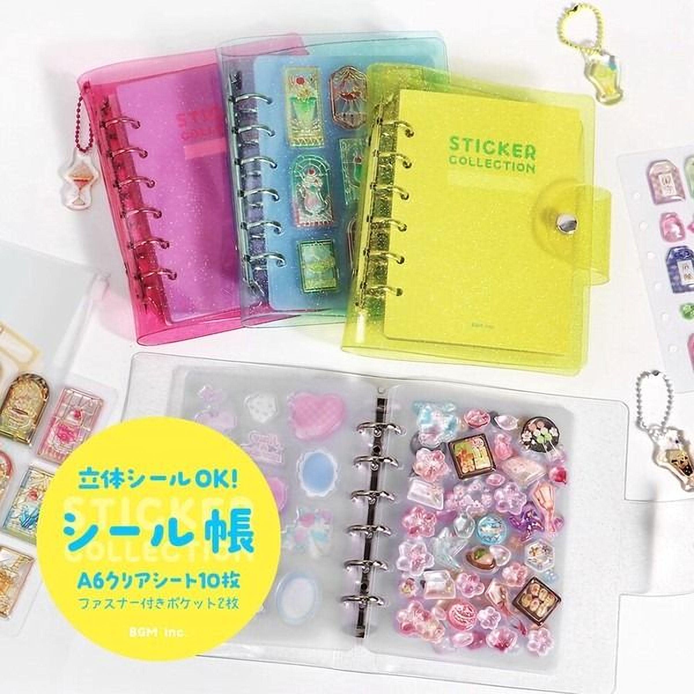 A collection of colorful notebooks and stickers, including a yellow sticker book and a pink notebook, along with various stickers and charms.