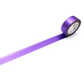 A roll of purple tape with a white label is lying on a white surface.