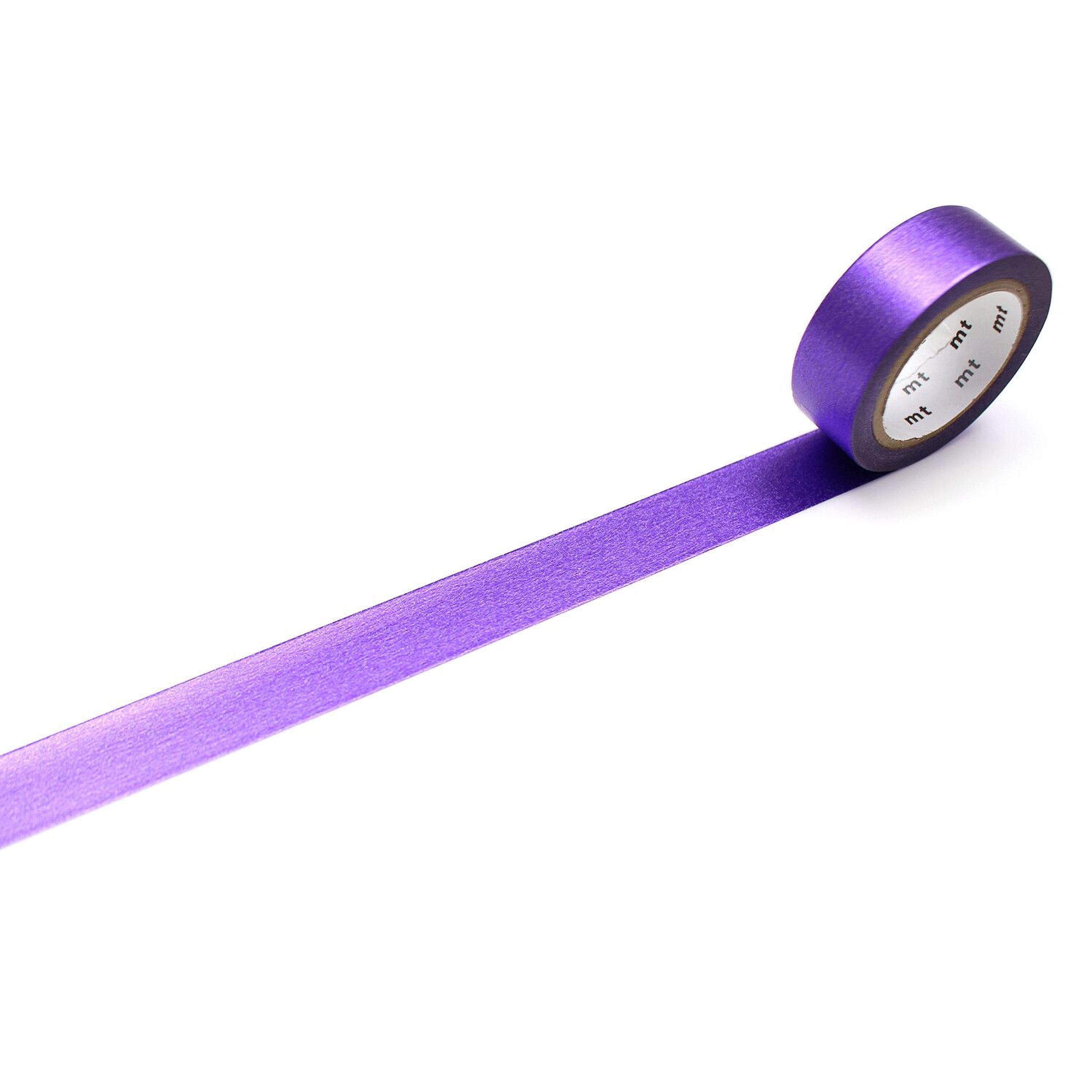 A roll of purple tape with a white label is lying on a white surface.