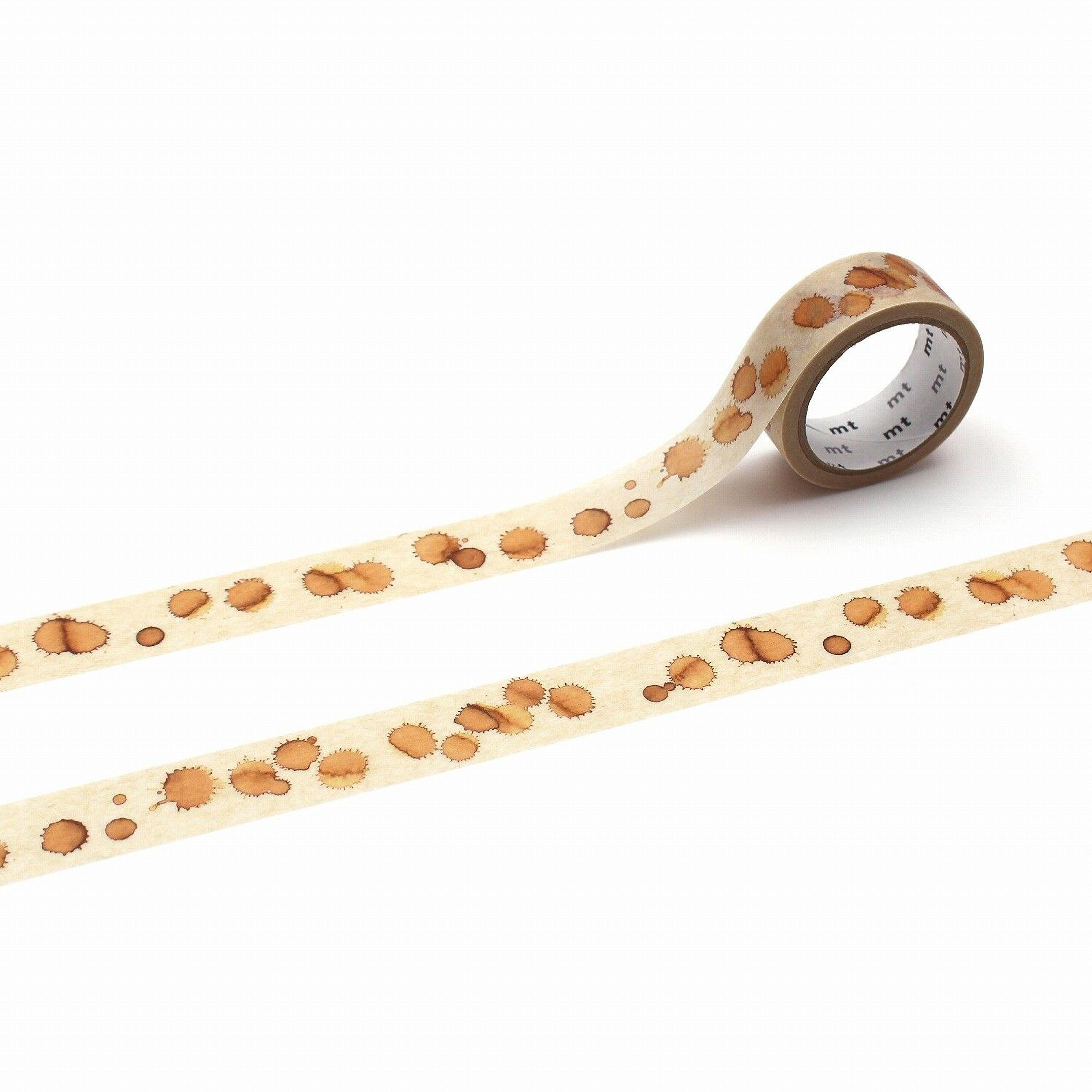 a roll of beige tape with a pattern of coffee stains on it, lying on a white surface.
