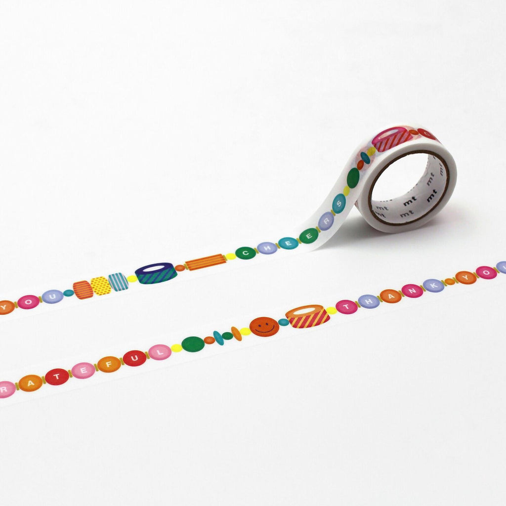 a roll of colorful tape with a pattern of beads and smiley faces on it.