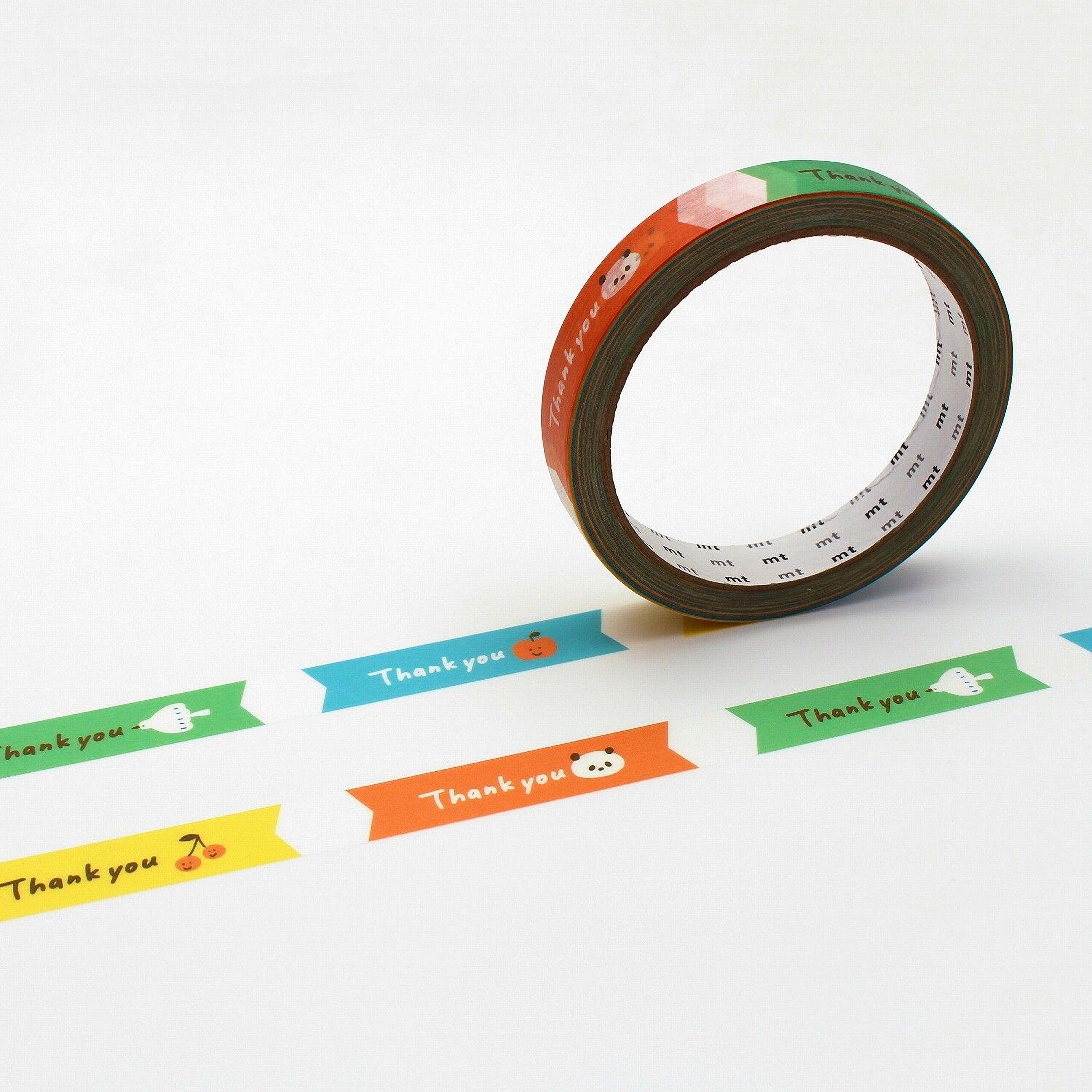 a roll of colorful tape with the words "Thank you" printed on it, along with various cartoon-style illustrations of fruits and vegetables.