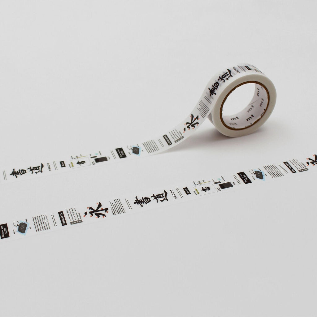 a roll of white tape with black text and graphics printed on it, lying on a white surface.