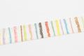 A white object with a striped pattern of various colors, including red, orange, yellow, green, blue, and purple.