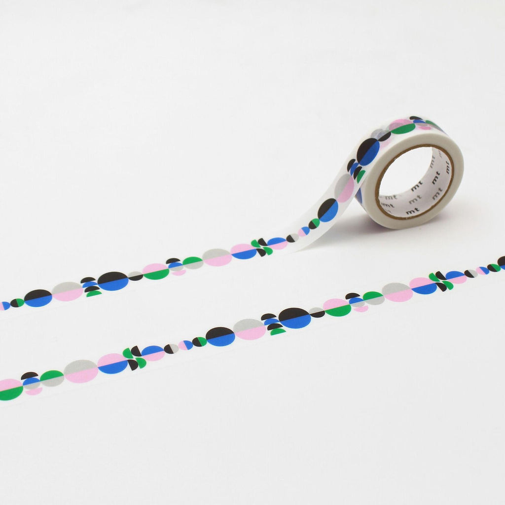 a roll of patterned tape with a repeating design of circles in various colors, including pink, blue, green, and gray.