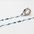 a roll of patterned tape with a repeating design of circles in various colors, including pink, blue, green, and gray.