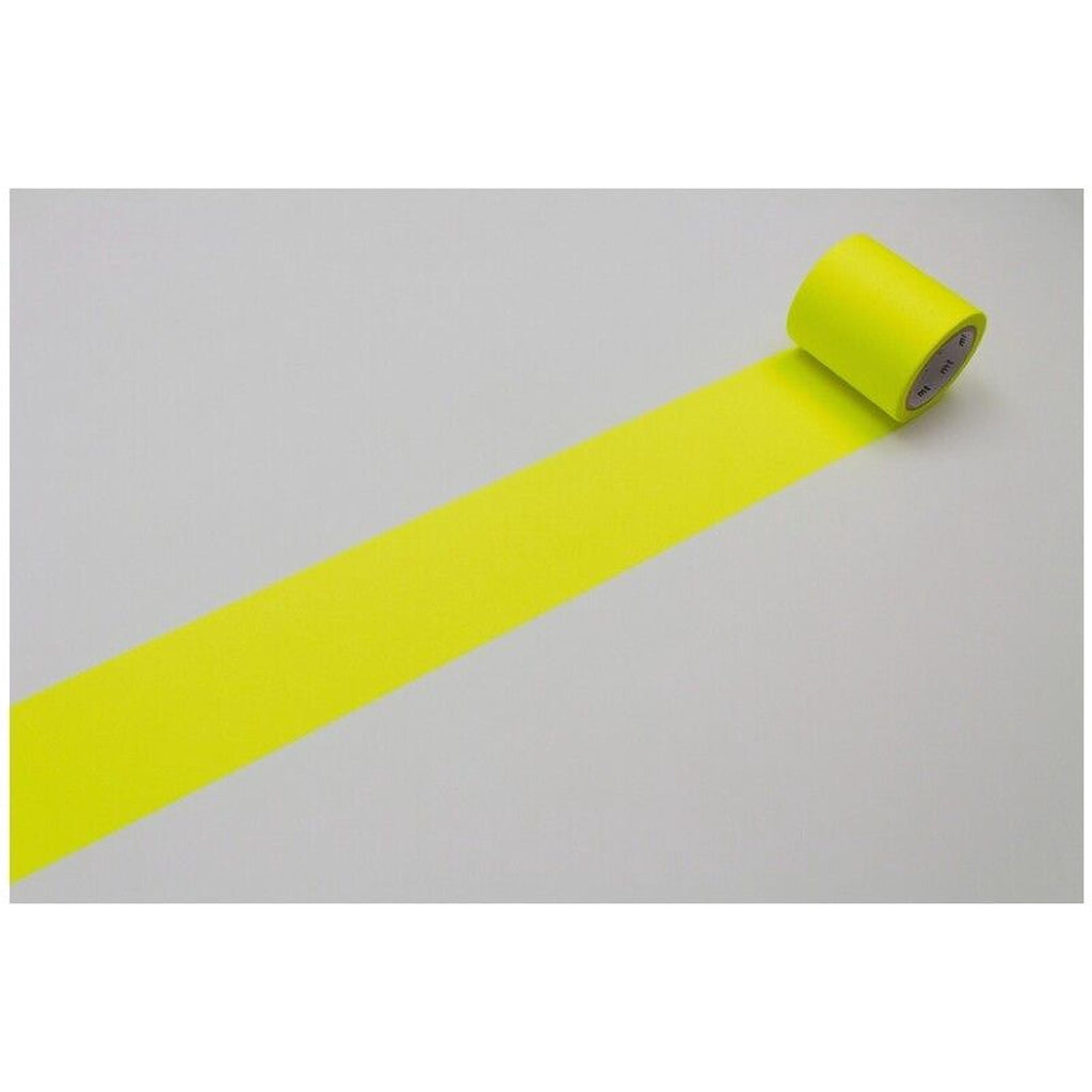 A roll of bright yellow tape is lying on a white surface, with the tape extending across the image.