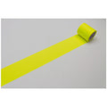 A roll of bright yellow tape is lying on a white surface, with the tape extending across the image.